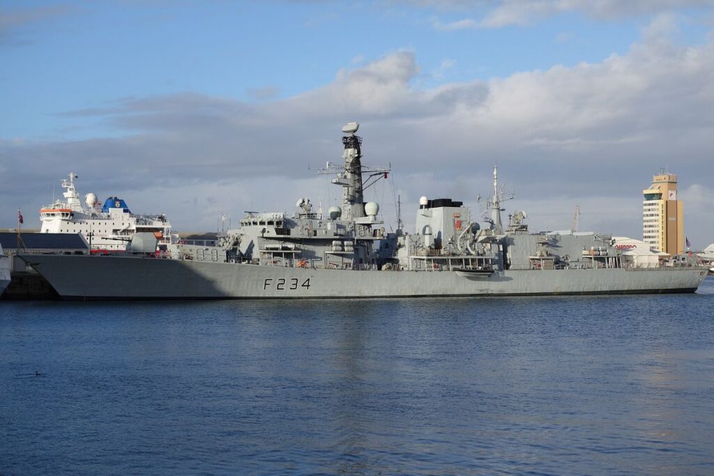 a frégate britannique HMS Iron Duke de la Royal Navy amarrée au Victoria Waterfront du Cap, en Afrique du Sud, en août 2014. Mise en service au début des années 1990, cette frégate de type 23 a longtemps été l’un des piliers de la lutte anti-sous-marine britannique, capable d’opérer loin des côtes du Royaume-Uni pendant plusieurs mois. Derrière sa silhouette discrète se cache pourtant une plateforme militaire conçue pour traquer les sous-marins dans l’Atlantique Nord durant les dernières années de la Guerre froide.Crédit : Farawayman — photo personnelle, 20 août 2014.