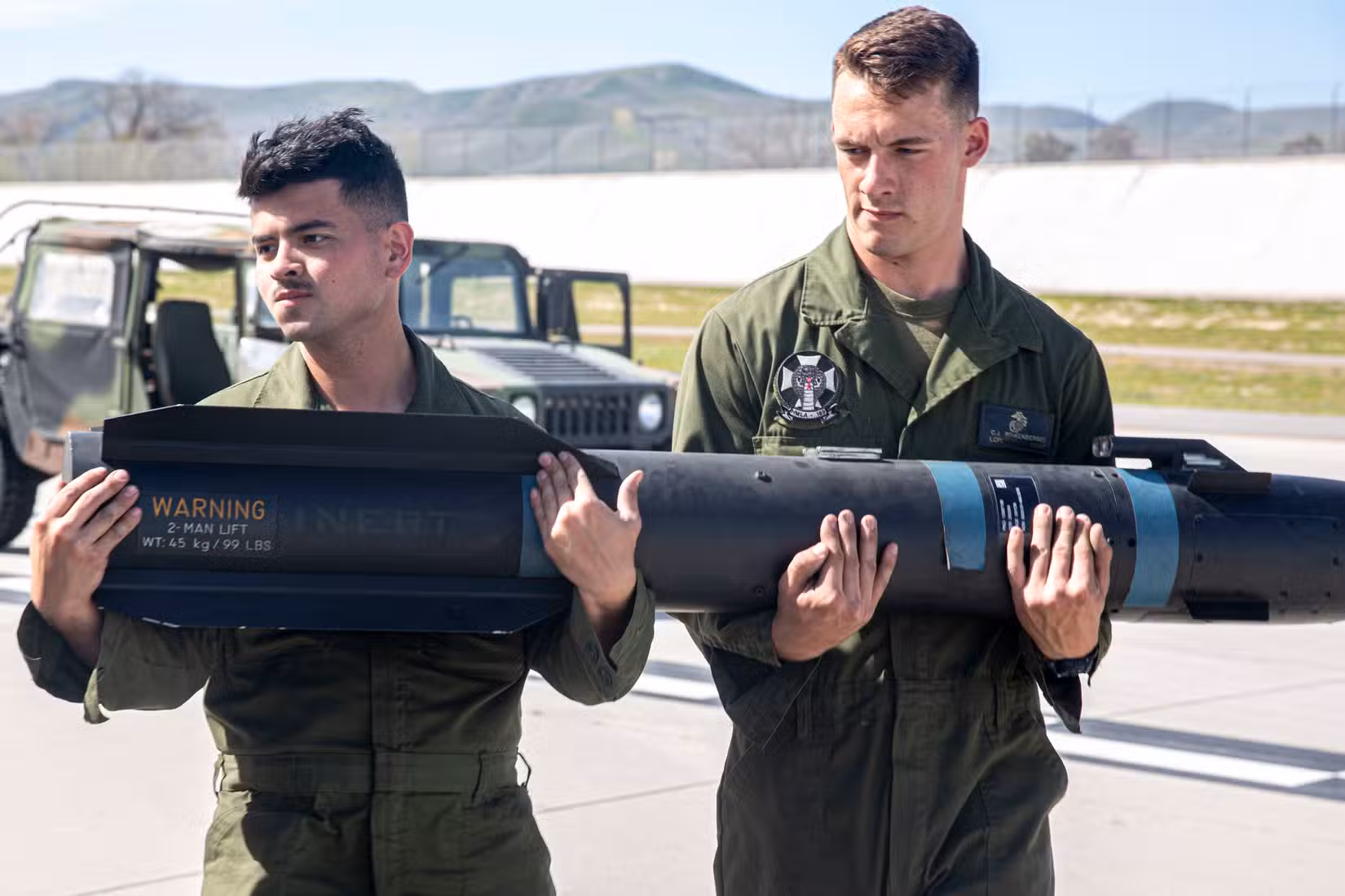 Les caporaux Dwightwayne Young et Carson Rinkenberger, techniciens en armement aéronautique de l'escadron d'hélicoptères d'attaque légers 169 (MLAH-169), du groupe aérien 39 (MAG-39) et de la 3e escadre aérienne (MAG-39), transportent un missile AGM-114 Hellfire à la base aérienne du Corps des Marines de Camp Pendleton, en Californie, le 20 février 2020. (Photo du Corps des Marines des États-Unis par le caporal Dylan Chagnon)
