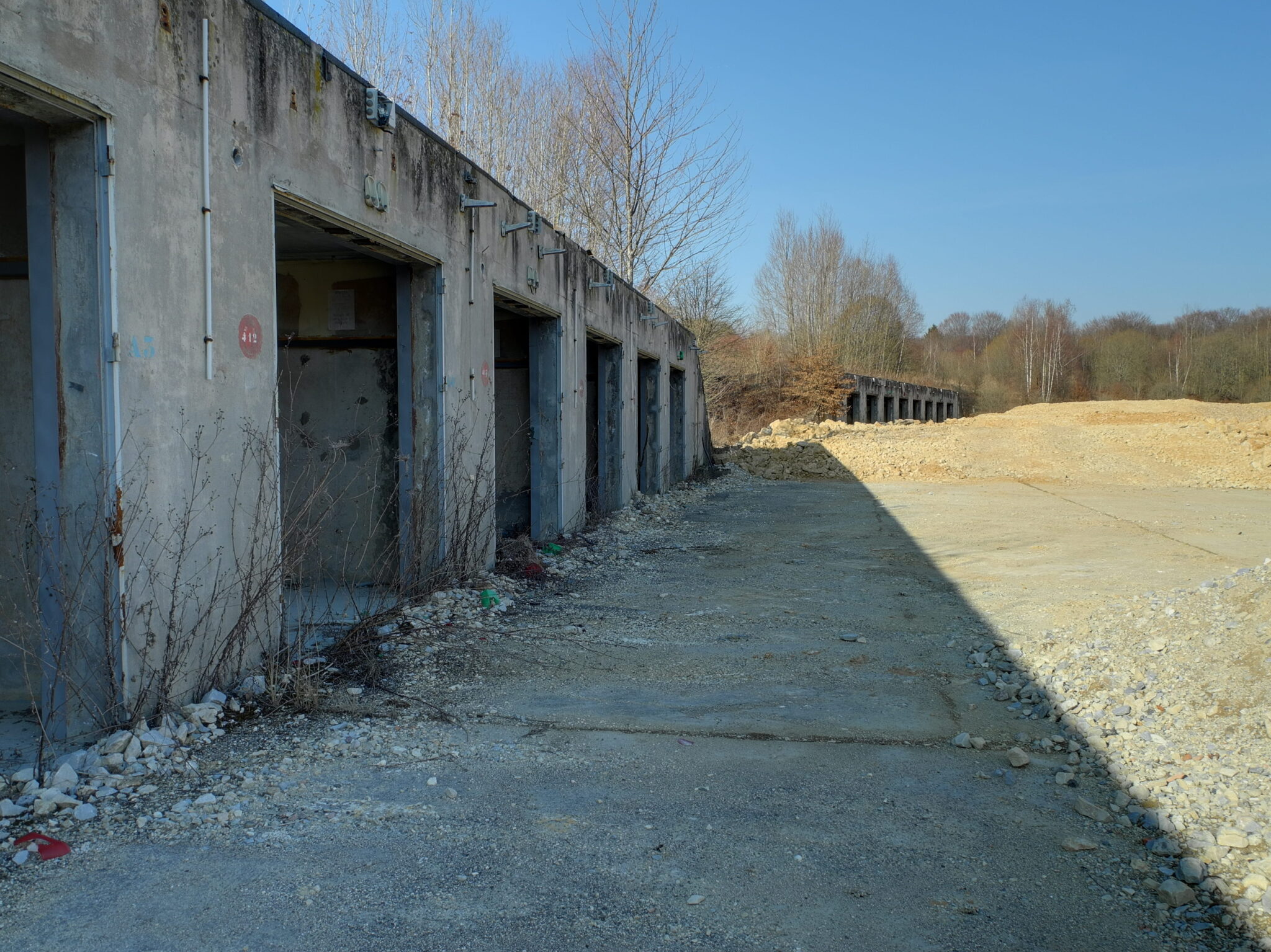 Rangée de garages bétonnés à l'abandon sur l'ancien site de missiles Pluton de Bourogne, dans le Territoire de Belfort